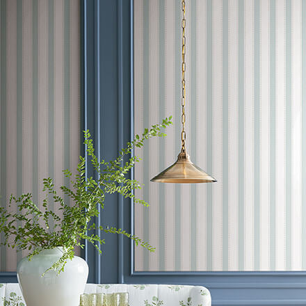 Dining room with striped wallpaper, wooden table, and chairs.