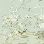Chinoiserie wallpaper featuring delicate white flowers, green birds, and a pheasant on a pale sage green background. The design includes a branch with blossoms, small birds perched on branches, and a pheasant near the bottom center.