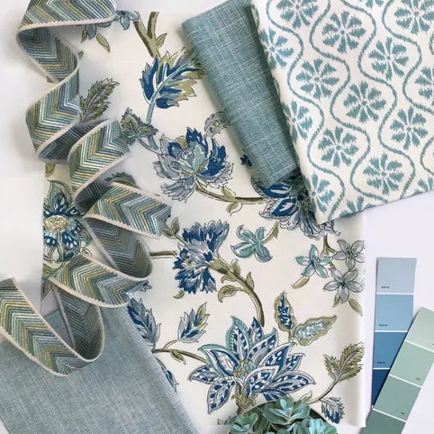 Collection of blue and green patterned fabrics and color swatches on a white background