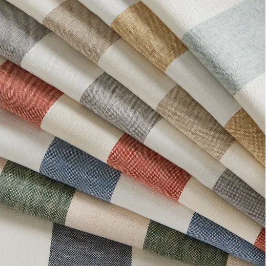 Folded striped fabric in a multicolor palette of beige, gray, blue, green, and terracotta on a white background.