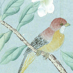 Vintage-style bird illustration of a small bird perched on a branch with green leaves and white flowers against a pale blue background.