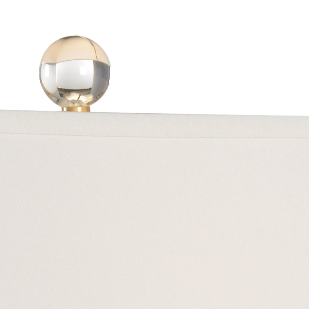 Close up of crystal finial on table lamp with white shade 