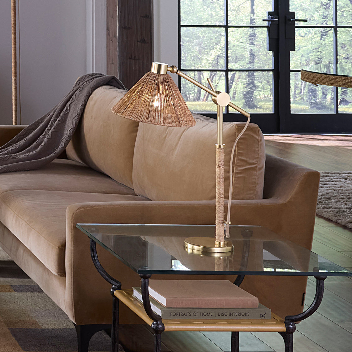 Modern living room with a beige sofa, glass coffee table, and wooden floor.