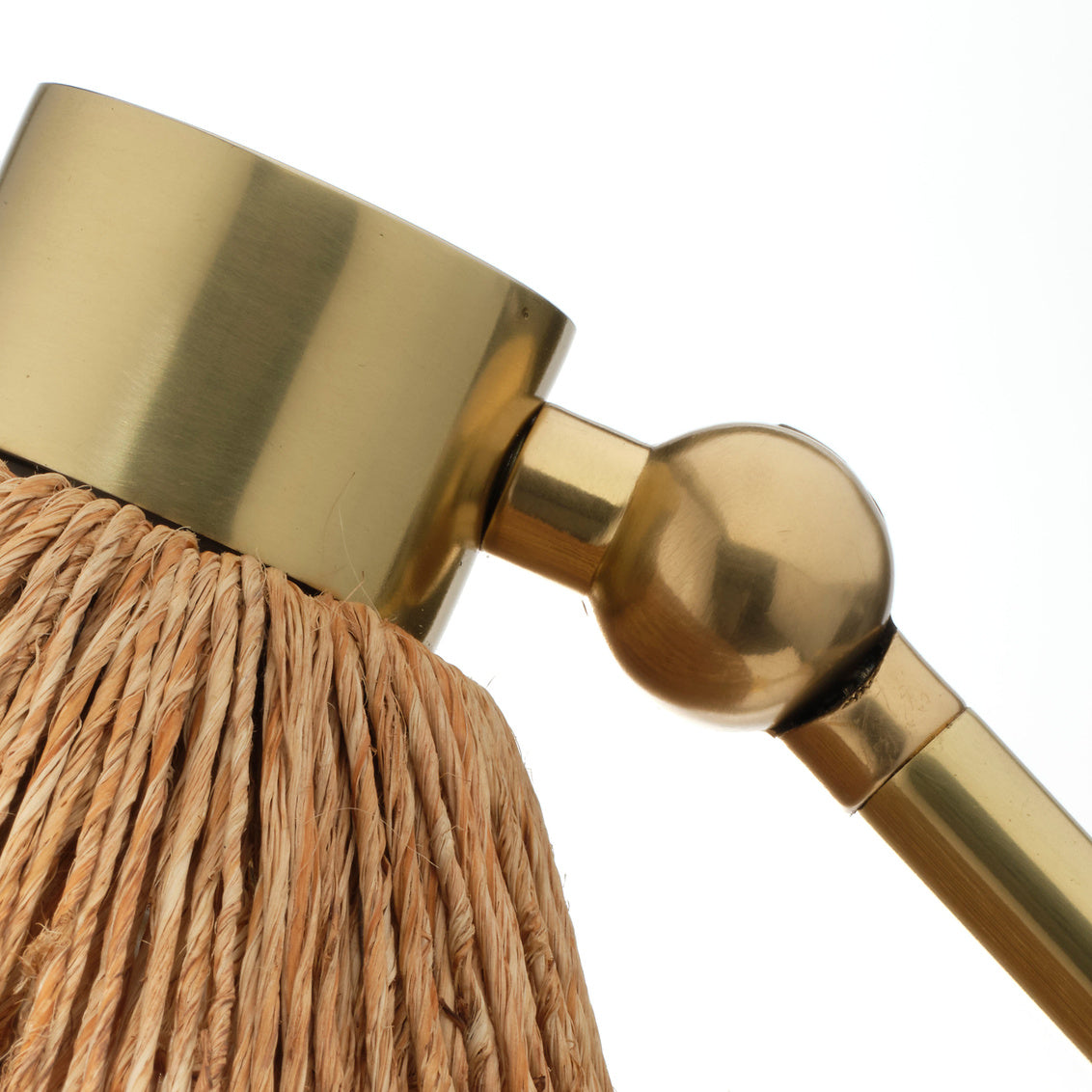 Close-up of a gold table lamp with a textured finish on a white background