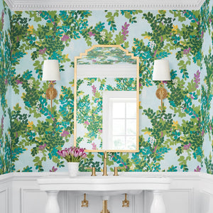Decorative wall with floral wallpaper, mirror, and wall sconces.