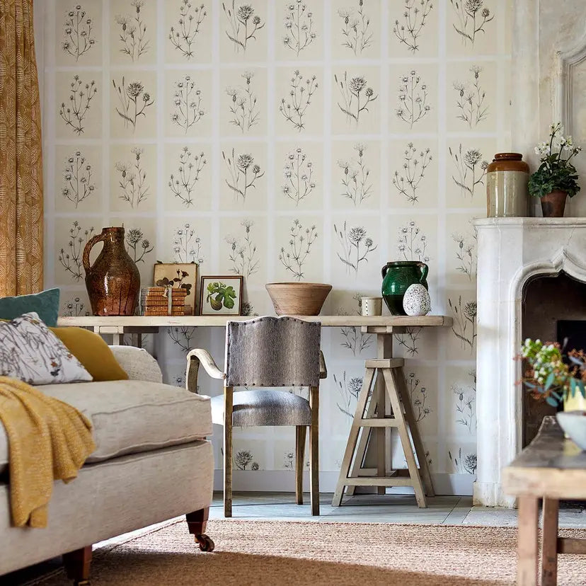 Cozy living room with floral wallpaper, a fireplace, and decorative items.