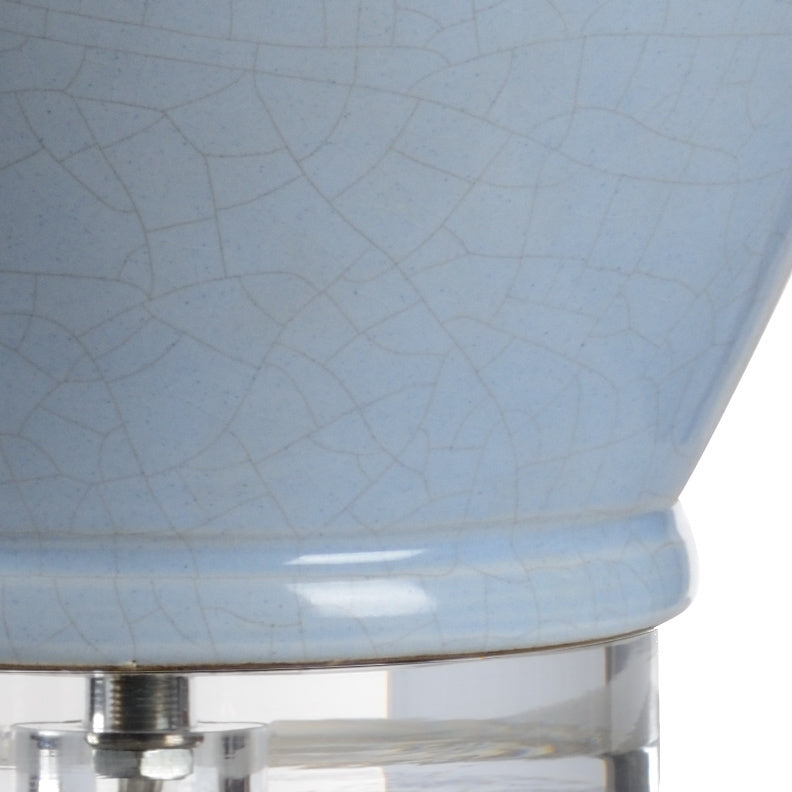 Close-up of a light blue ceramic lamp with a textured surface on a white background