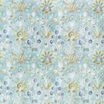 Floral patterned fabric with green and aqua flowers on a light blue background