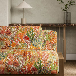 Colorful coral and sea life fabric-patterned sofa in a modern living room setting.