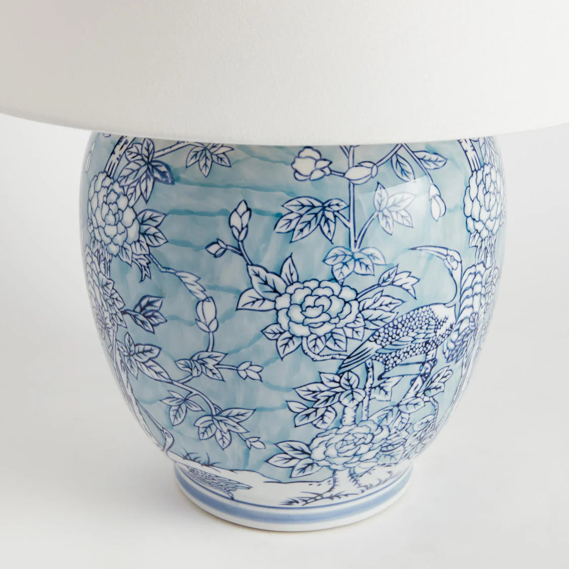 Ceramic lamp base with blue floral pattern on a white background