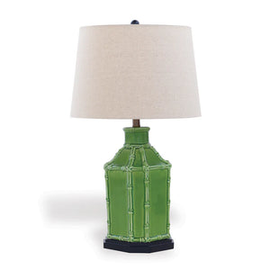 Green table lamp with a white lampshade on a white background