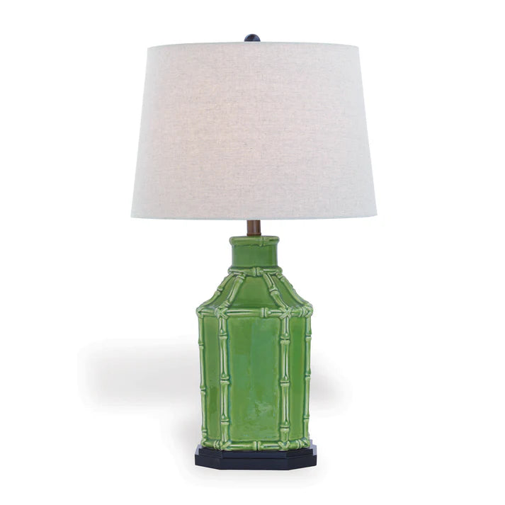 Green table lamp with a white lampshade on a white background