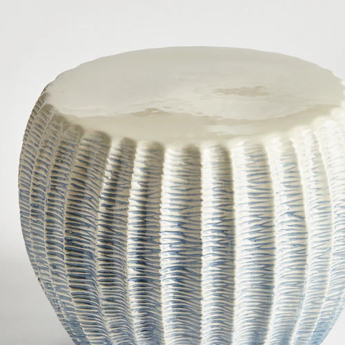 Close-up of a textured ceramic stool with ribbed design on a white background