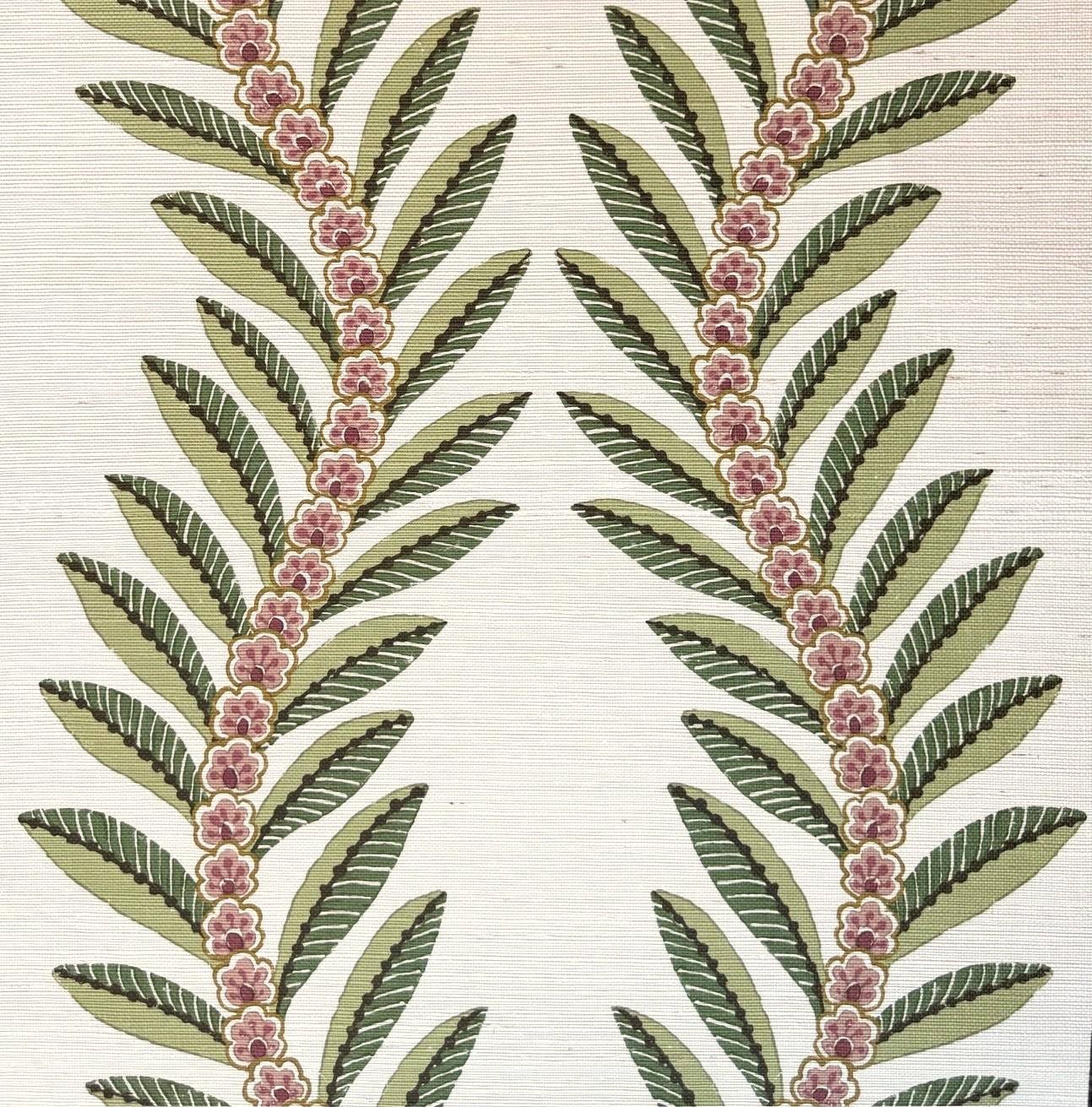 A close-up of a textile or wallpaper pattern featuring two vertical botanical motifs with olive green leaves and small pink flowers on a warm off-white background.