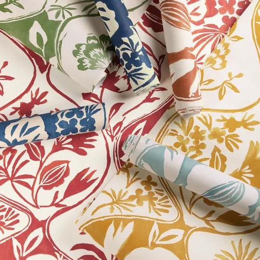 Rolls of colorful floral and geometric patterned wallpaper on a white background