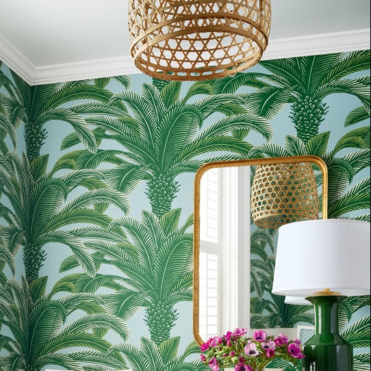 Dining room with palm tree-patterned wallpaper, wooden table, and chairs.