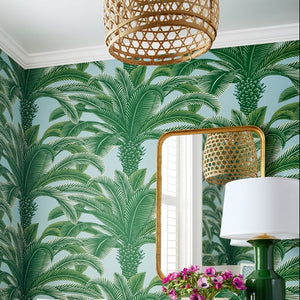 Dining room with palm tree-patterned wallpaper, wooden table, and chairs.
