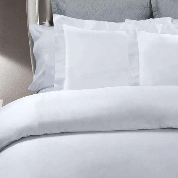 White bedding set on a bed with gray headboard