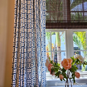 Patterned curtain with a window and flowers in the background