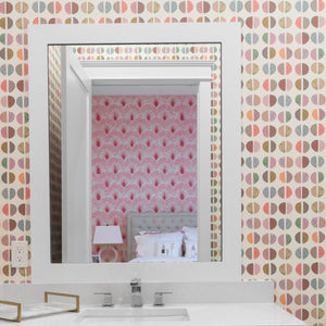 Bathroom vanity with patterned wallpaper and mirror
