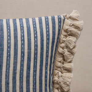 Striped pillow with tassels on a beige background