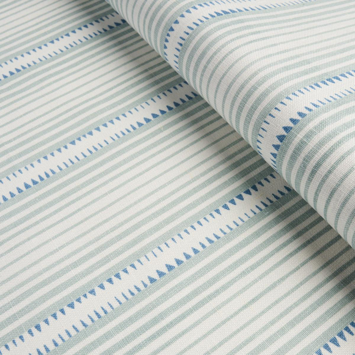 A close up of striped aqua fabric on white ground 