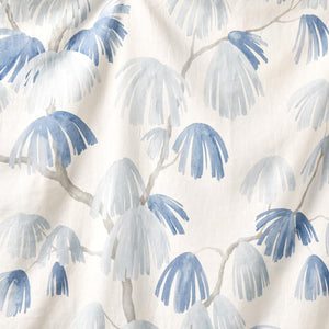 A section of fabric with a pattern of weeping pine trees in blue on a beige background.