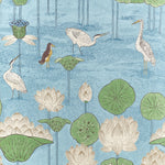 A repeating botanical and bird pattern on a light blue background, featuring white cranes, green lily pads, white lotus flowers, and a small brown bird.