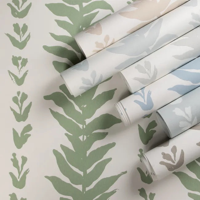 Rolls of wallpaper with leaf patterns on a light background