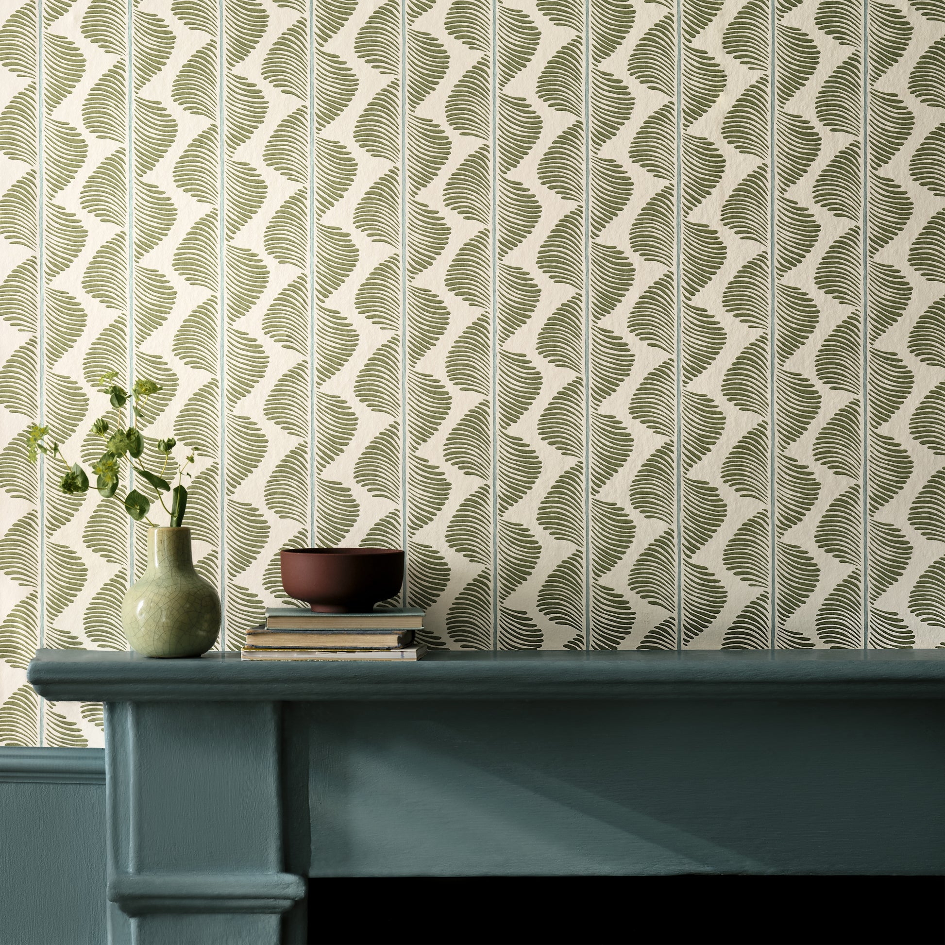 Wallpaper with a geometric pattern on a wall next to a teal cabinet.