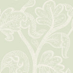 A close-up of a wallpaper pattern featuring a delicate, light cream botanical design with stylized leaves and swirling vine motifs on a soft sage green background.