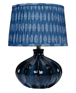 Blue table lamp with a patterned shade on a white background