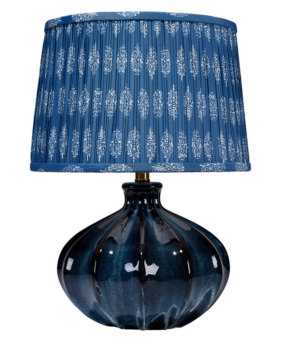 Blue table lamp with a patterned shade on a white background