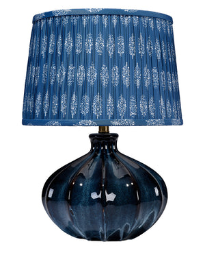 Blue table lamp with a patterned shade on a white background