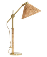 Gold table lamp with a wicker shade on a white background