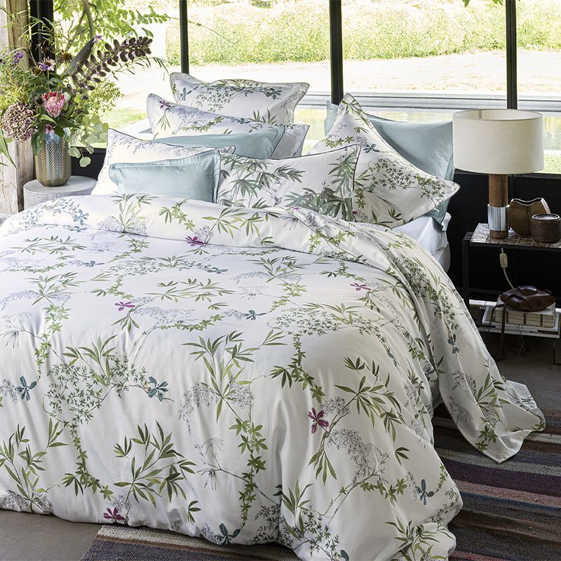 Floral bedding set on a bed with pillows in a bedroom setting.