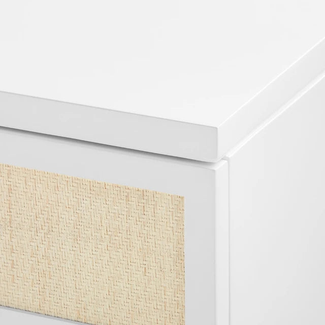 Close-up of a white dresser with a textured beige panel on a white background