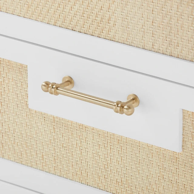Close-up of a drawer with a gold handle on a white and beige textured surface