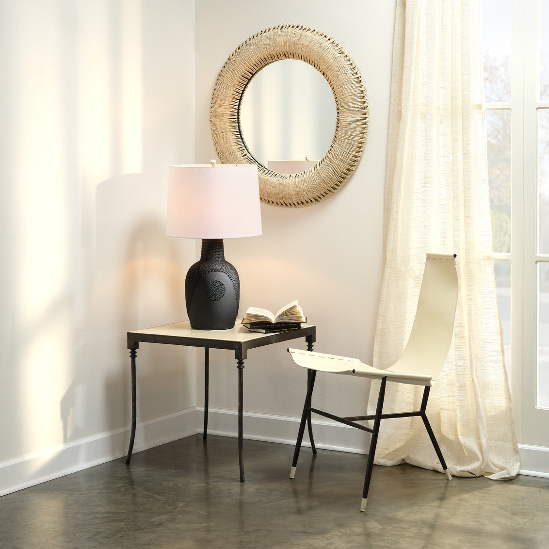 Corner seating area featuring rope round mirror on white wall