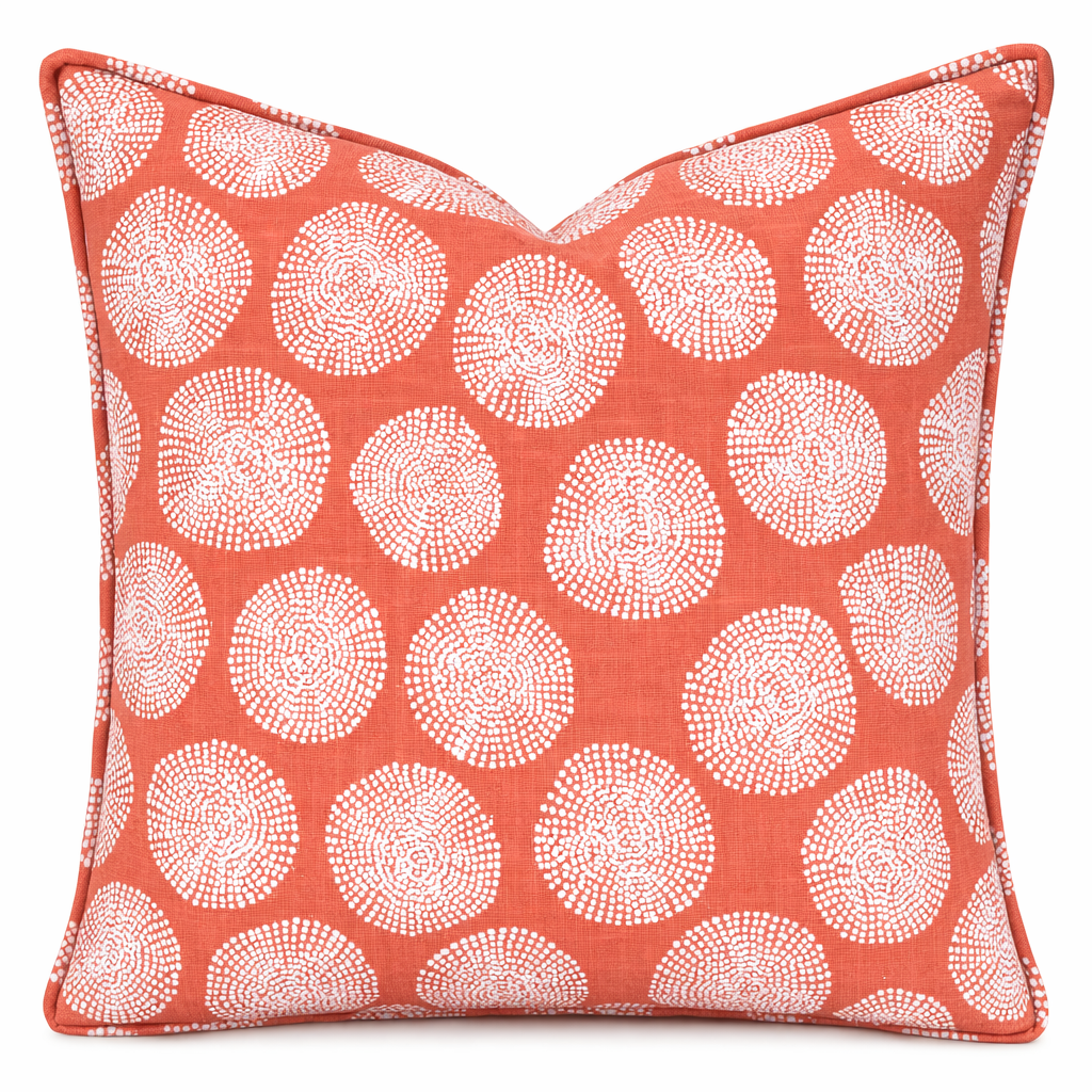 Decorative pillow with white circular pattern on a coral background
