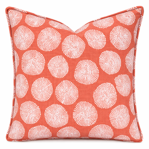 Decorative pillow with white circular pattern on a coral background