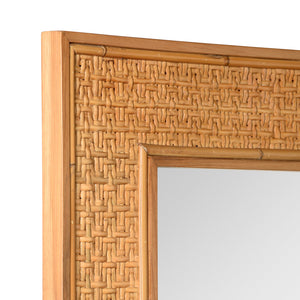 Close-up of a mirror with a woven rattan frame on a white background