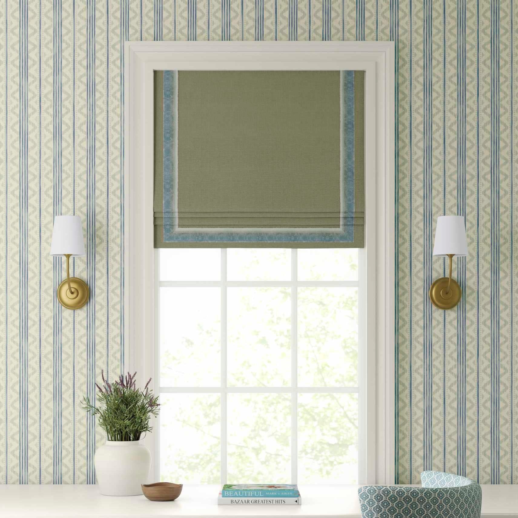 Decorative wallpaper with geometric pattern, window with blinds, and wall sconces.